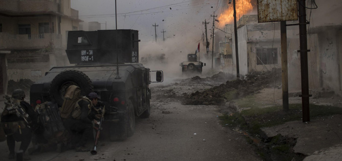 Felipe Dana/ Associated Press - Um carro bomba explode perto de veículos blindados pertencentes às Forças de Operações Especiais do Iraque em Mosul, Iraque